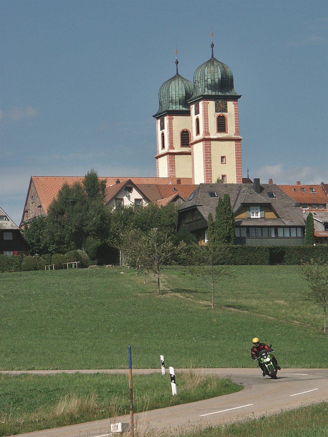 Motorrad auf einer Straße unter einer Kirche mit zwei Zwiebeltürmen Motorrad auf einer Straße unter einer Kirche mit zwei Zwiebeltürmen